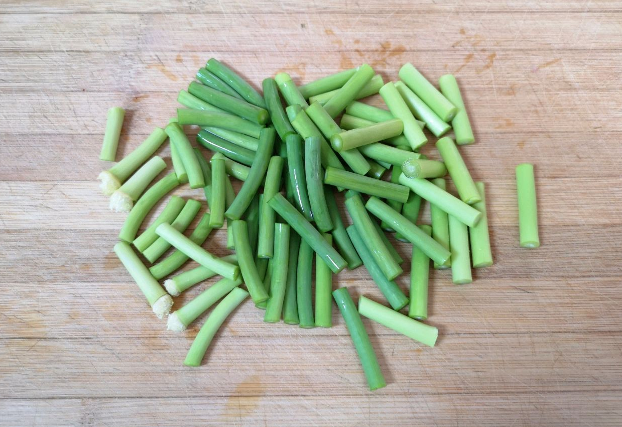 Cut 100g of garlic shoots into sections.