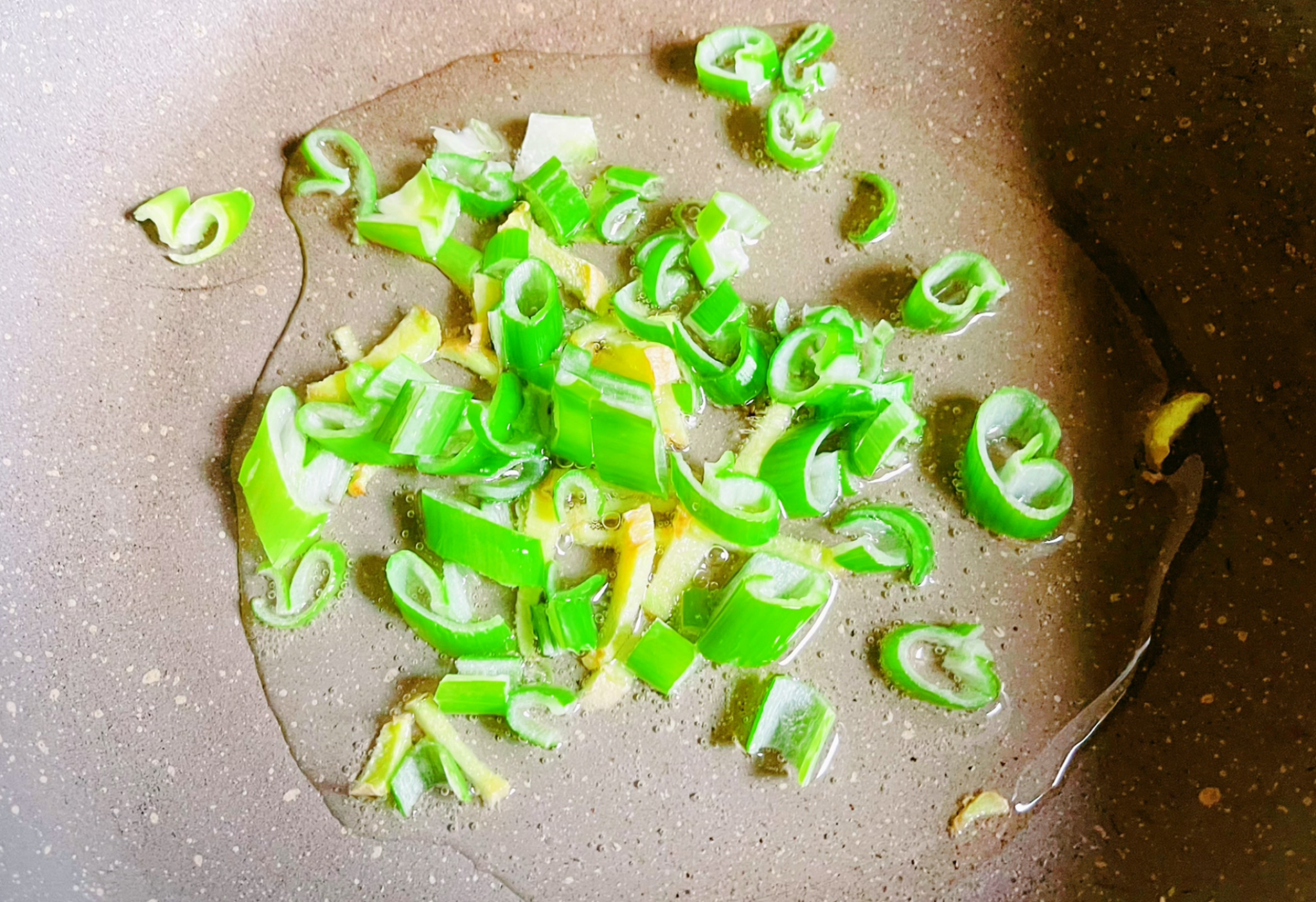 Chop and sauté 10g of green onions in cooking oil until fragrant.