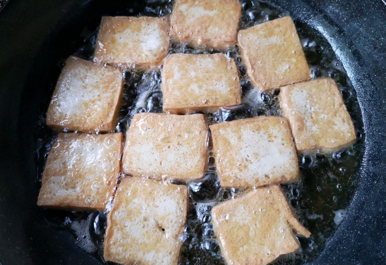 Fry tofu in hot oil until golden brown on both sides. Use non-stick pan for even cooking.