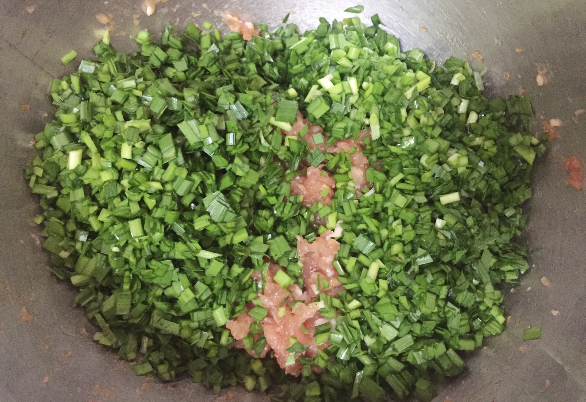 Wash and chop chives, add to marinated pork. Stir before wrapping to prevent water release.