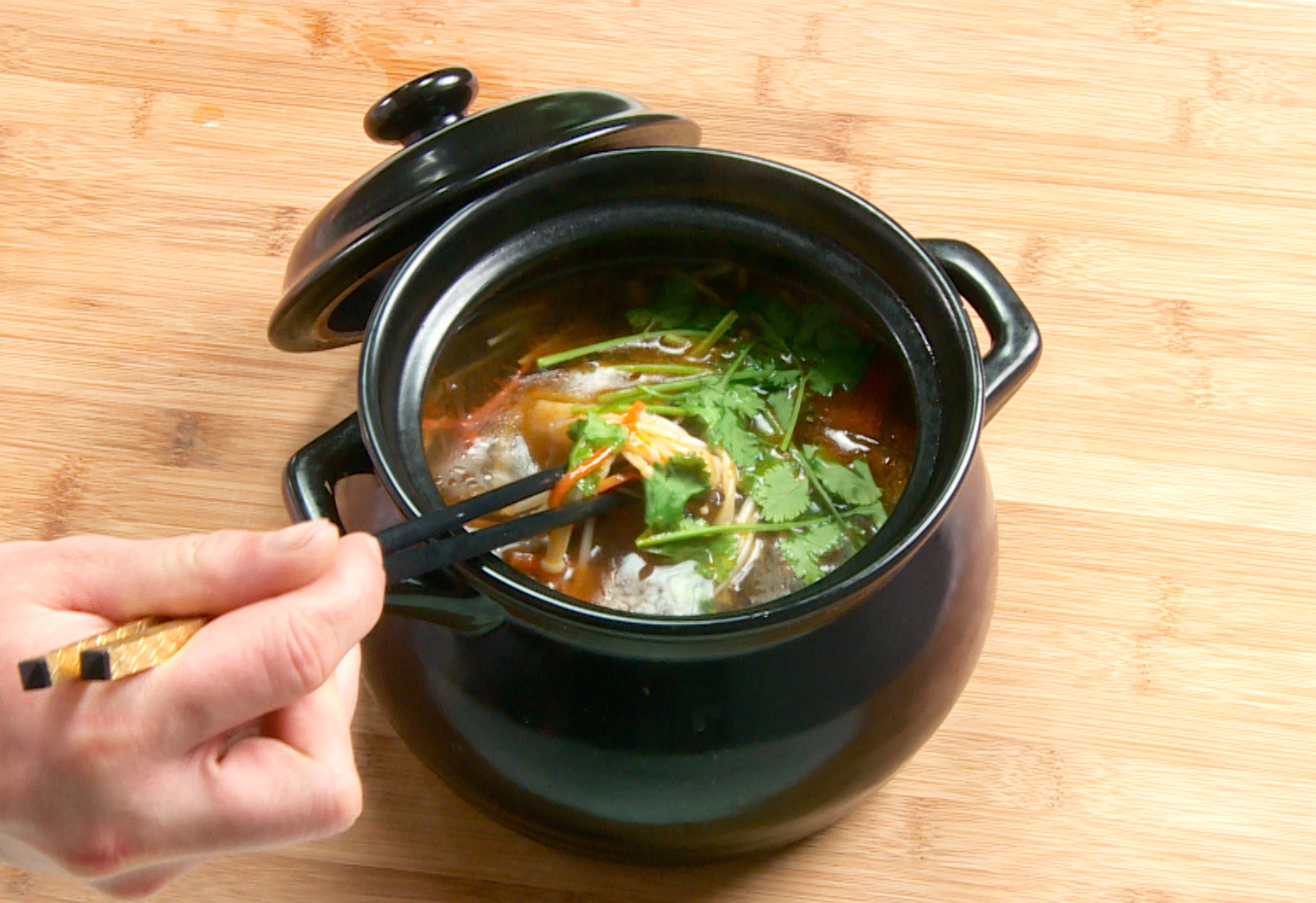 Add cilantro and serve hot for a delicious kelp and enoki hot pot.