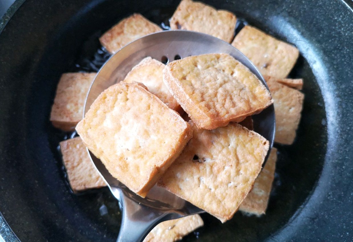 Fry tofu until golden brown and firm; push with spatula to prevent uneven cooking.