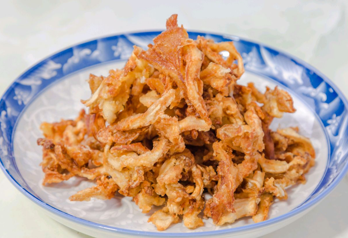 Fry mushrooms until golden brown, then drain excess oil.