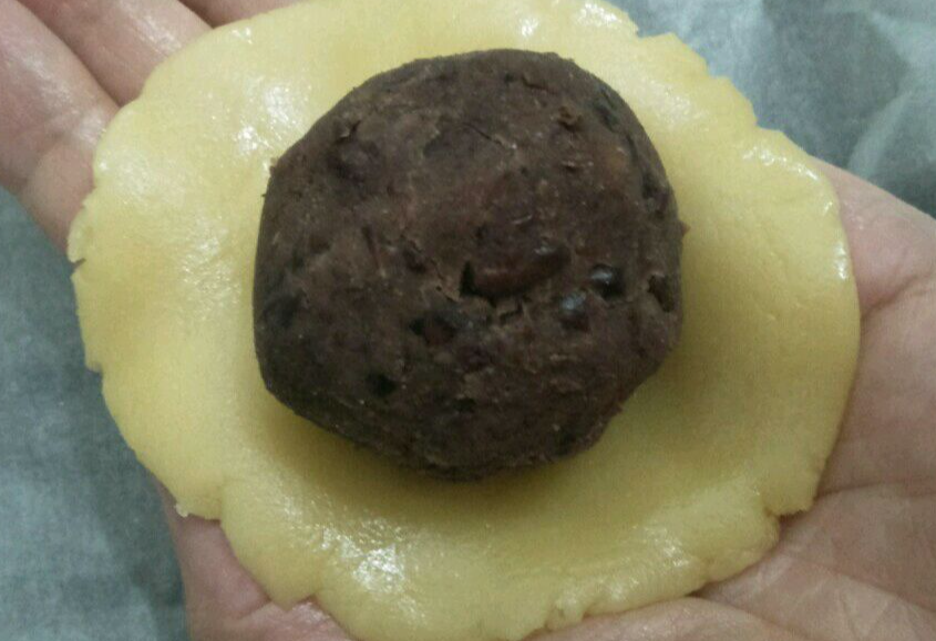 Wrap red bean paste in dough balls to create dumplings.