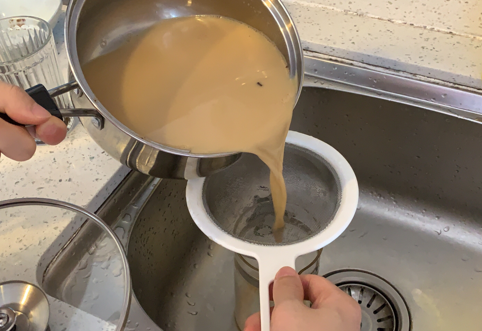 Tea leaves strained and tea poured into cups.