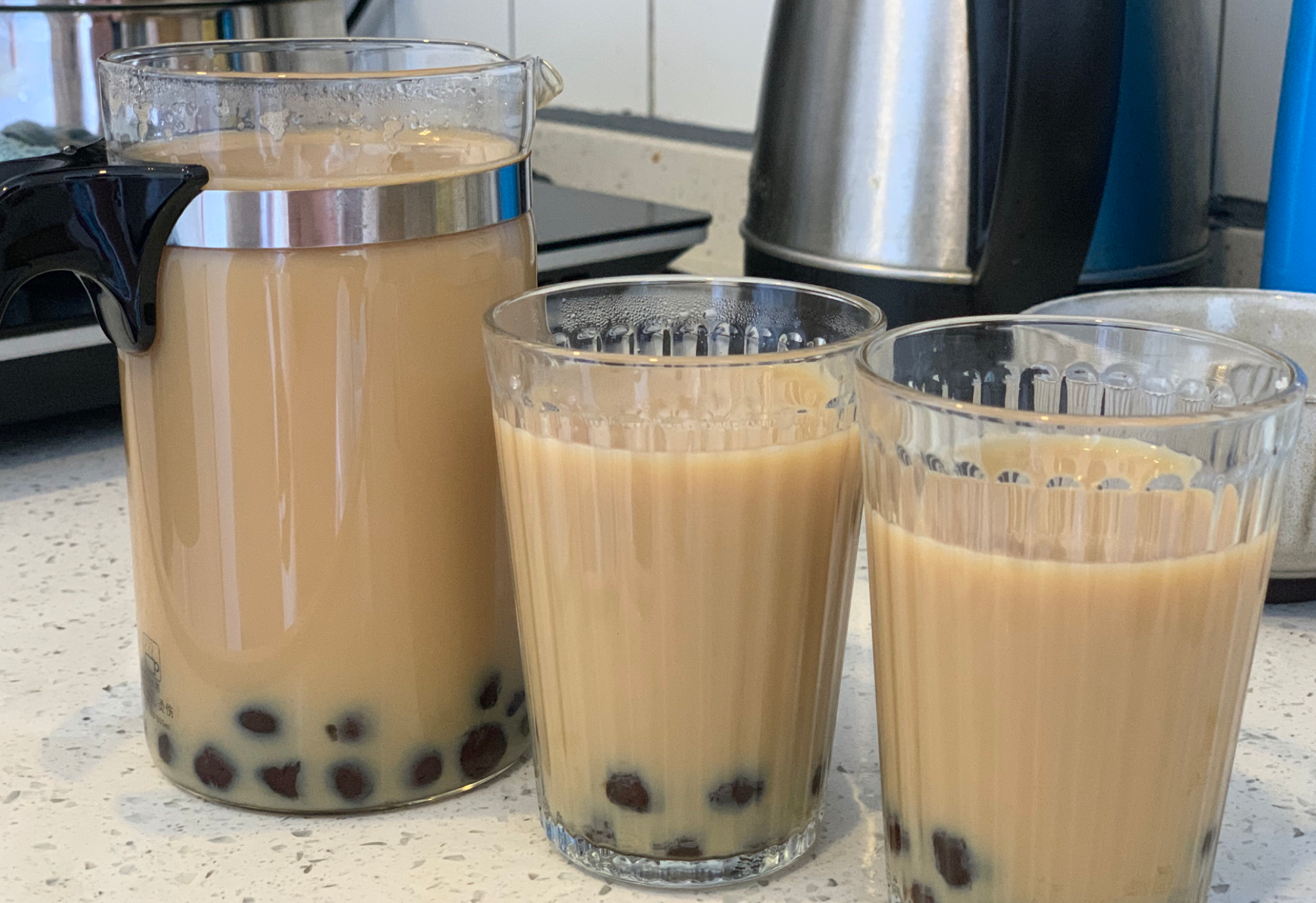 Make bubble tea by adding pearls to a glass cup, followed by milk tea. Delicious!