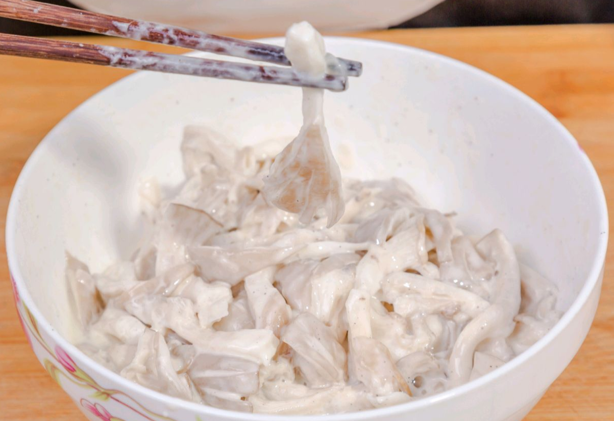 Coat torn oyster mushrooms in batter before frying.