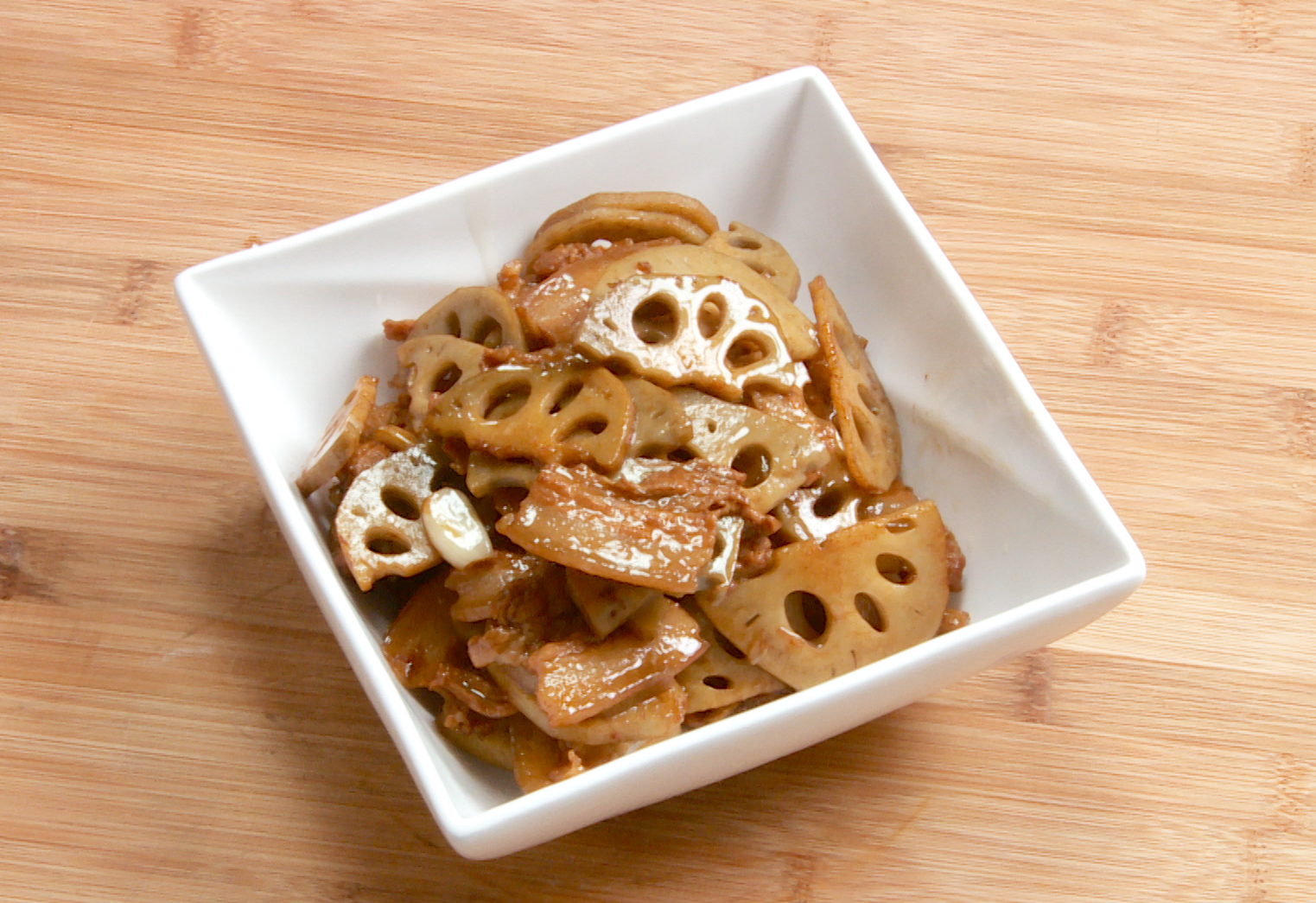 Serve the stir-fried pork belly and lotus root on a plate.