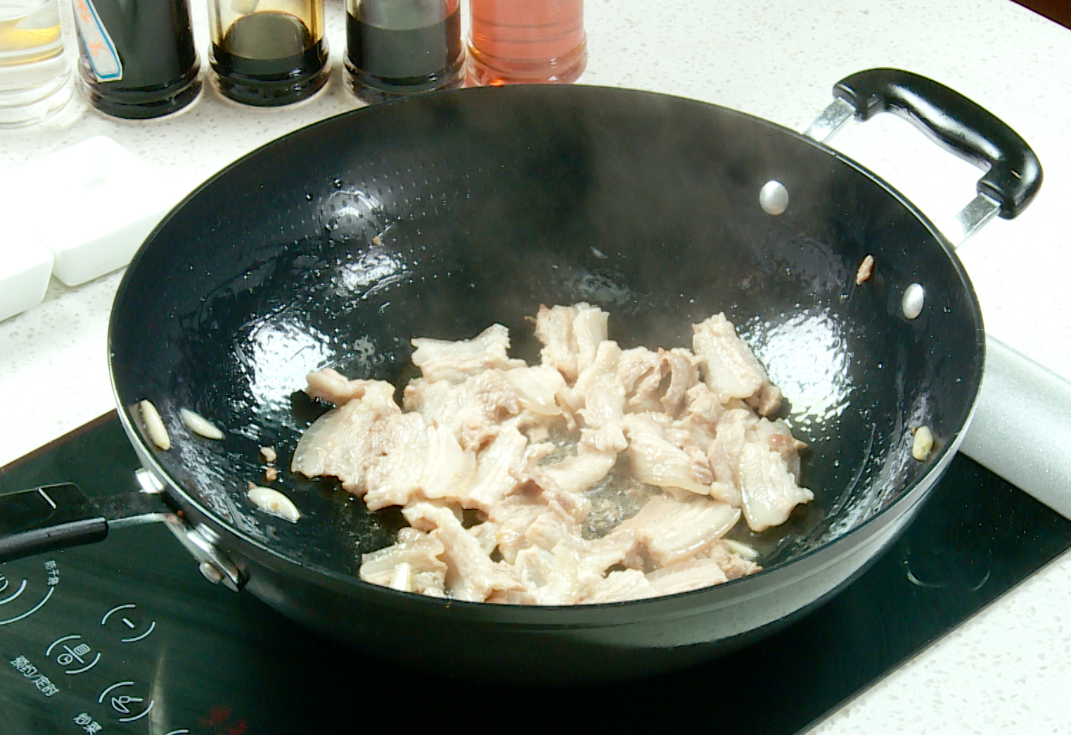 Stir-fry garlic and pork belly in hot oil until fragrant and fat renders.