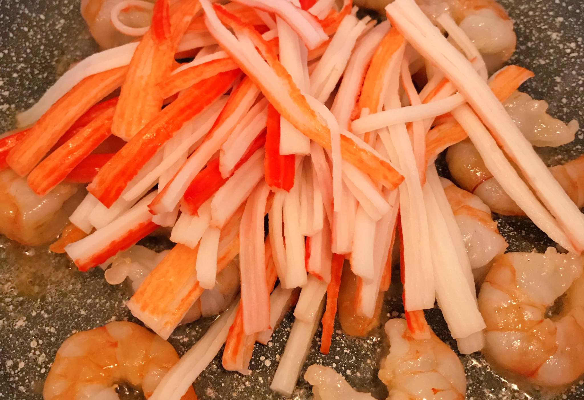 Stir-fry shrimp and imitation crab for 20 seconds.