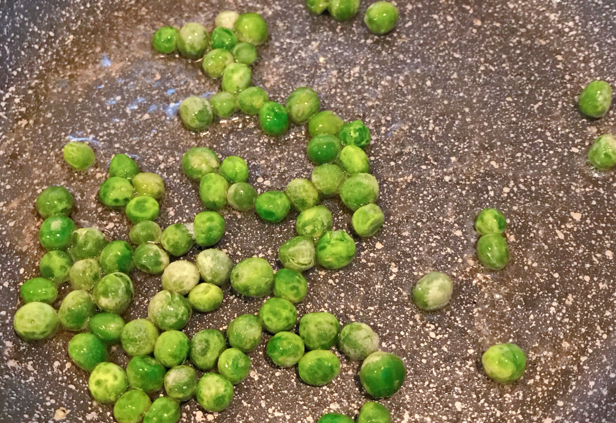 Stir-fry green peas in 5g cooking oil and 15g sesame oil for 30 seconds.