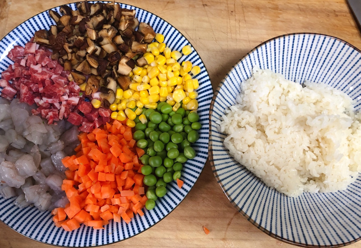 Clean and dice carrot, mushrooms, sweet corn, shrimp, and peas for recipe.