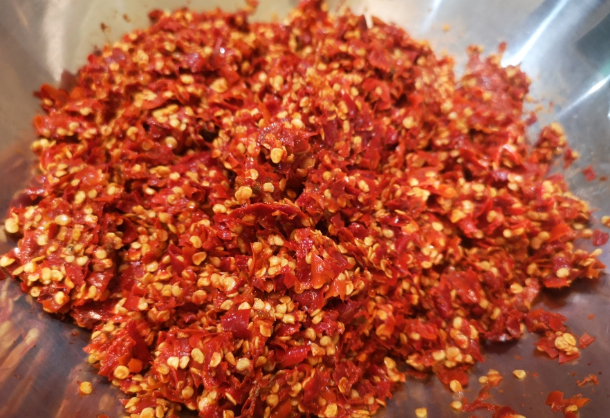 Soak dried chili peppers, then blend until finely chopped.