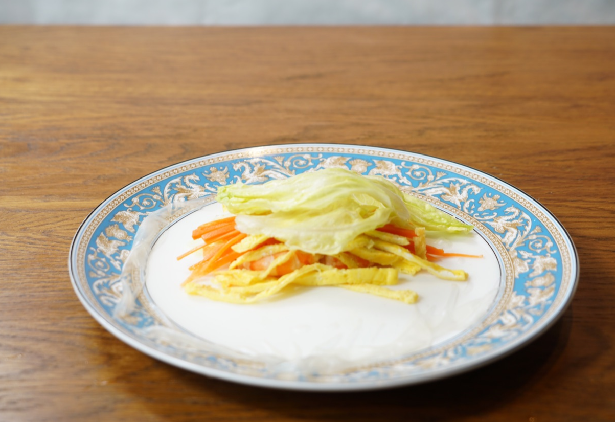 Layer shrimp, egg, veggies, and lettuce on softened rice paper.