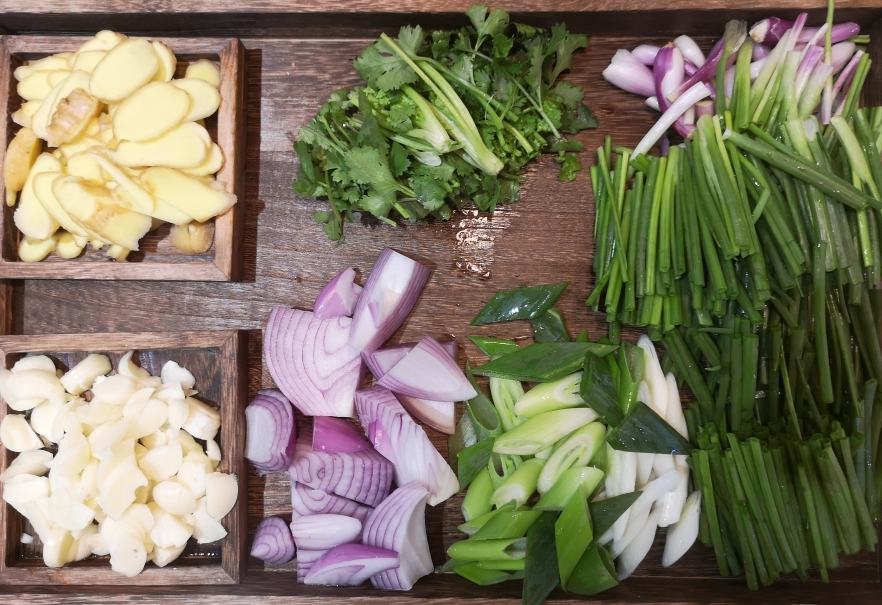 Prepare seasoned vegetables: ginger, garlic, cilantro, onions, scallions, and shallots. Set aside.