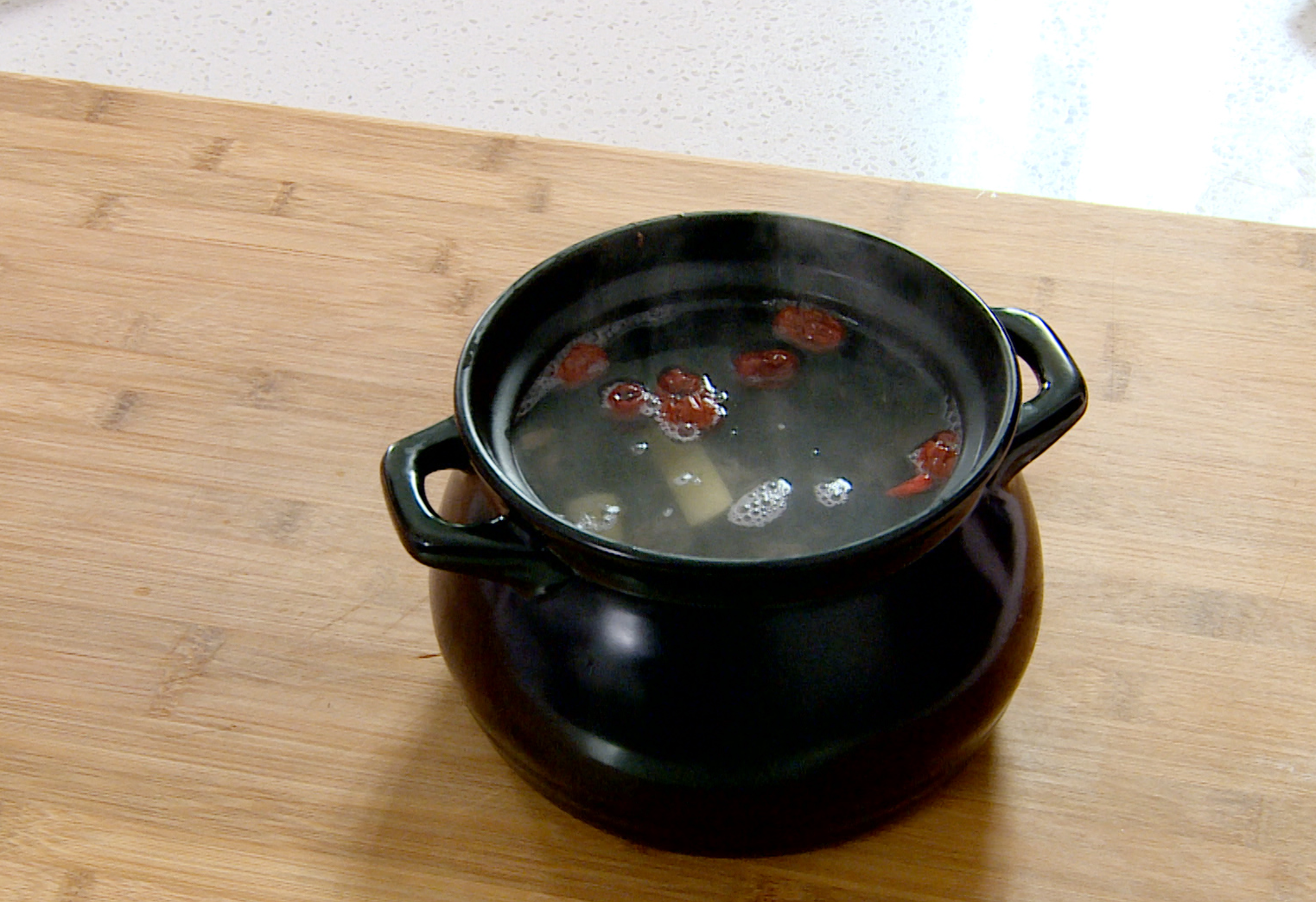 Simmer chicken soup with red dates, ginger, longan, and goji berries for 3 hours.