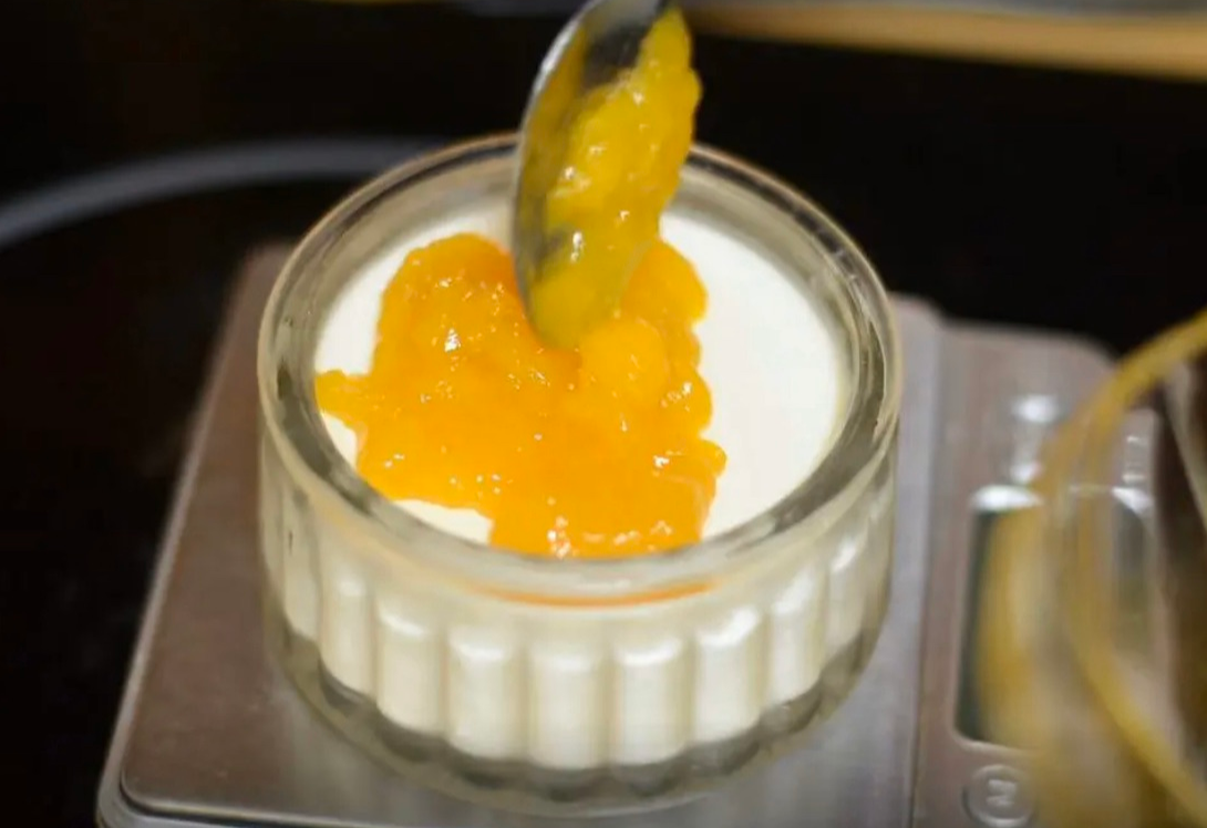 After 4 hours, add cooled mango sauce to Panna Cotta in molds.