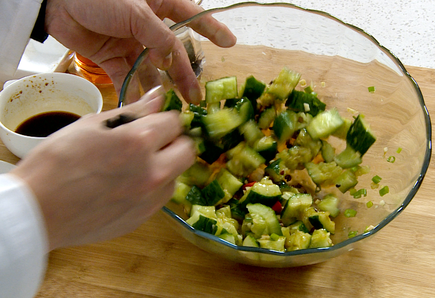 Finish the salad by pouring Sichuan pepper oil and chili oil, toss to coat cucumbers.