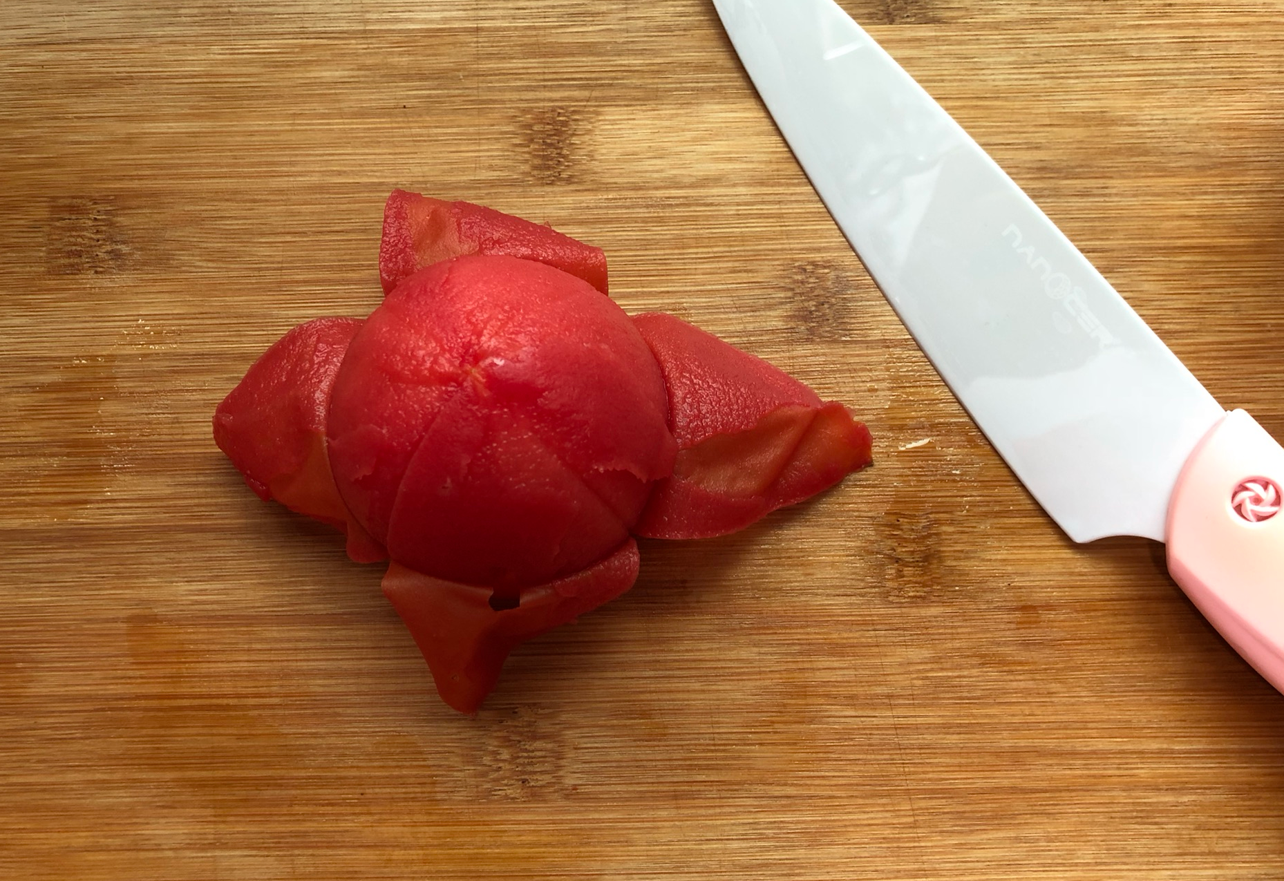 Peel the skin off cooled tomatoes.