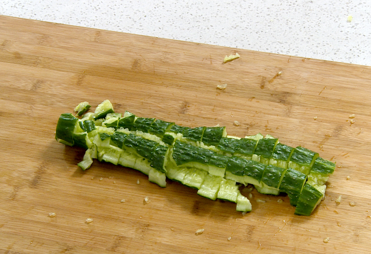 Prepare cucumbers by washing, smashing with the flat side of a knife, and cutting into pieces.