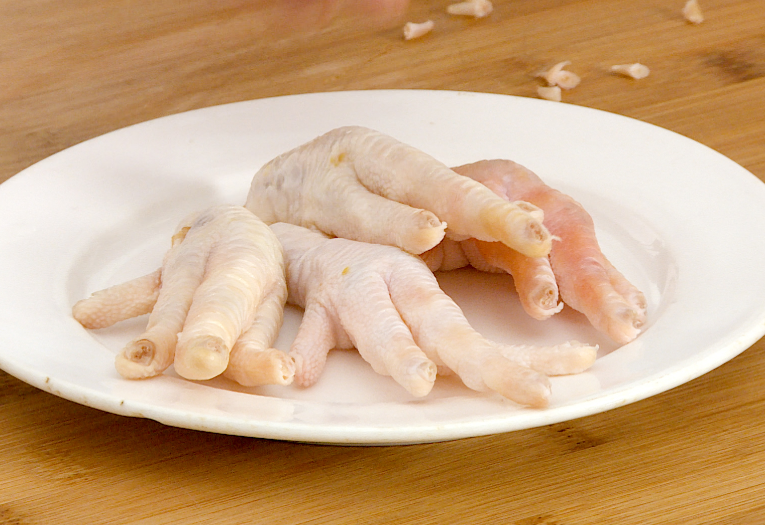 Trim nails off 1 pound of chicken feet to prepare them.