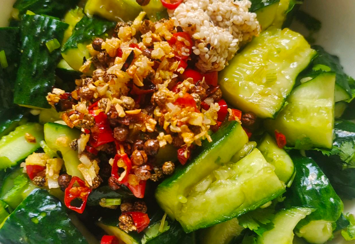 Pour hot ginger, garlic, cilantro, chili mixture over cucumbers & add sesame seeds.