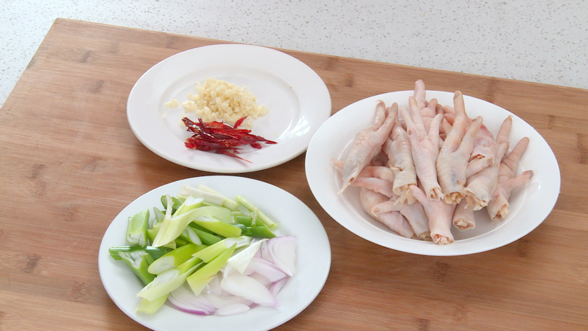 Cut scallion, onion, garlic, and chili peppers for vegetable preparation.