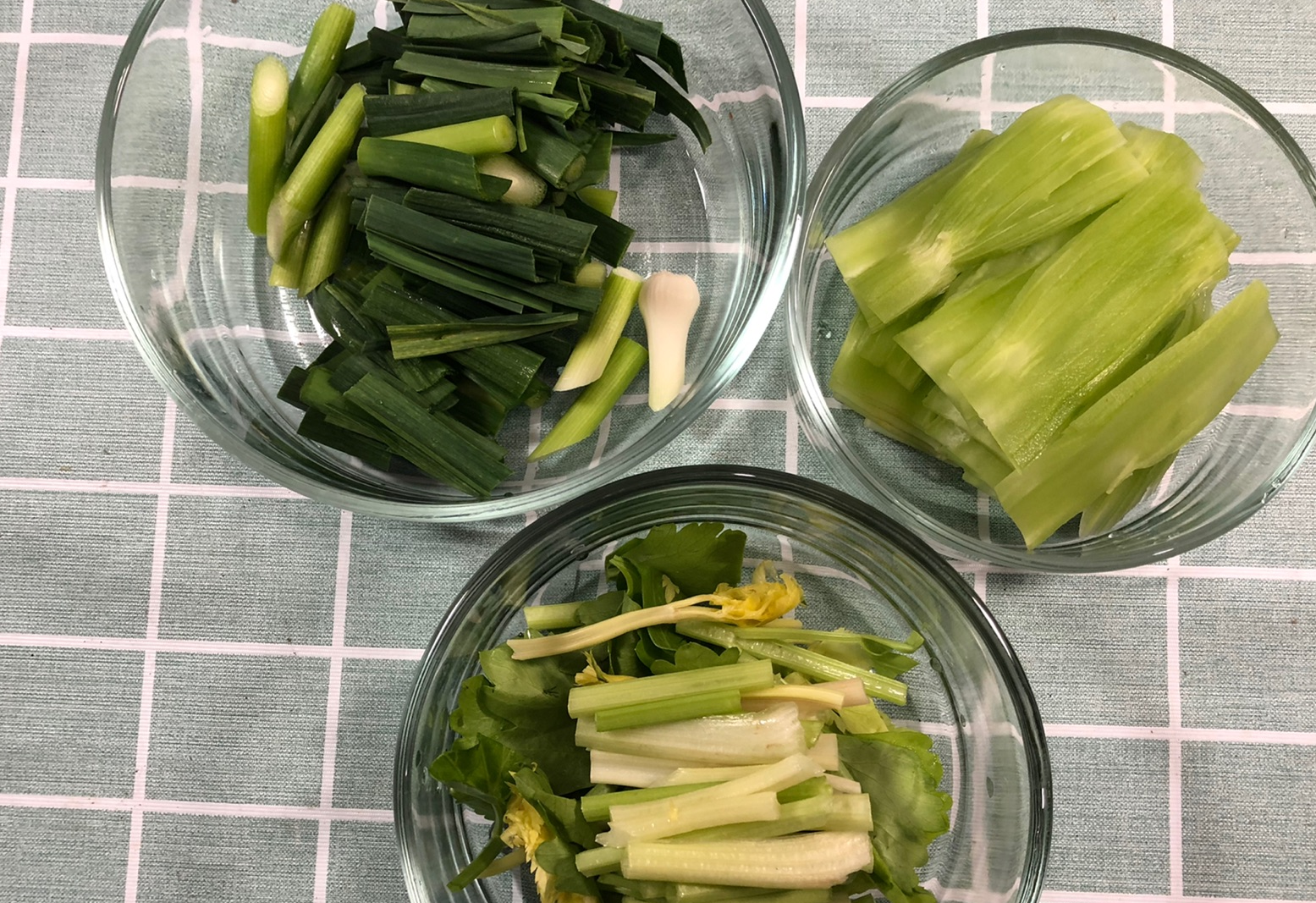 Prepare vegetables for stir-fried fish: wash, cut celery, garlic shoots, slice bamboo shoots.