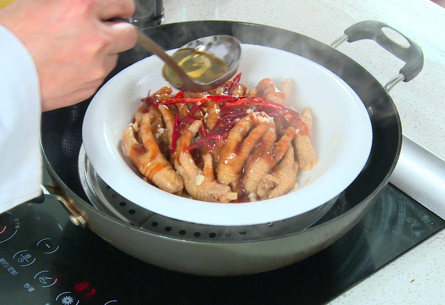 Finish steaming chicken feet with garlic, chili peppers, sauce, sesame oil for 15 minutes.