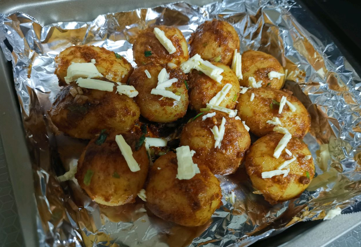 Preheat oven, line sheet with foil, arrange marinated potatoes, add butter. Bake at 200°C for 20 mins using top and bottom heat. Be mindful of oven temps to avoid burning.