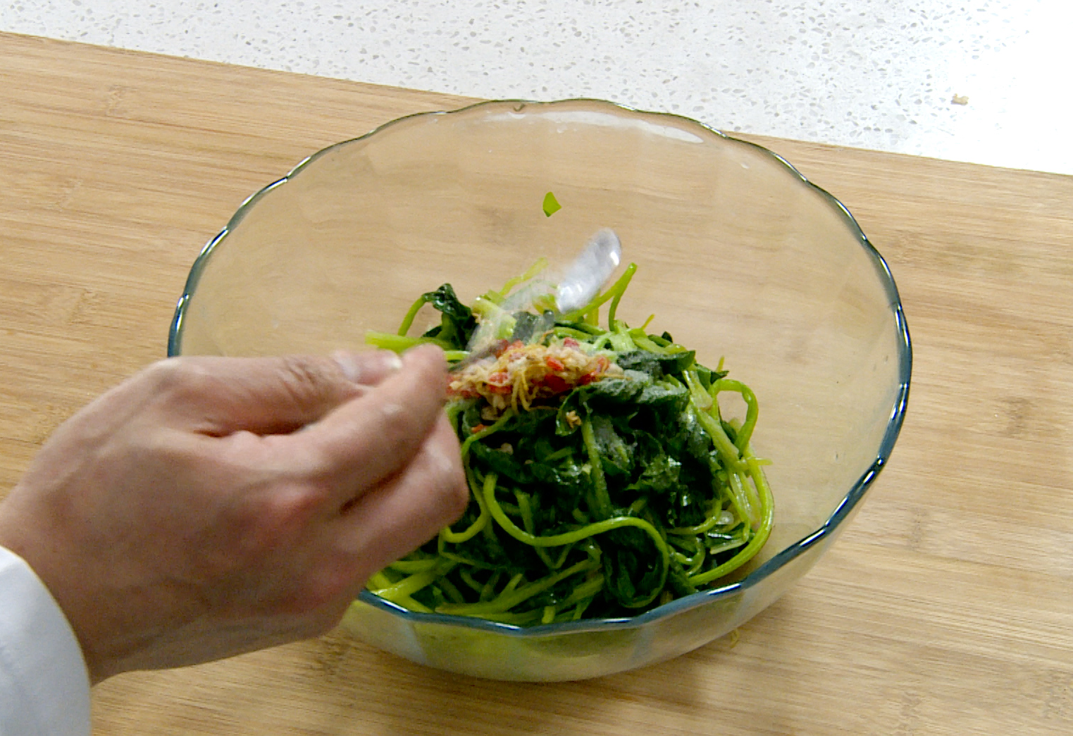 Dress blanched spinach with aromatic mixture and salt.