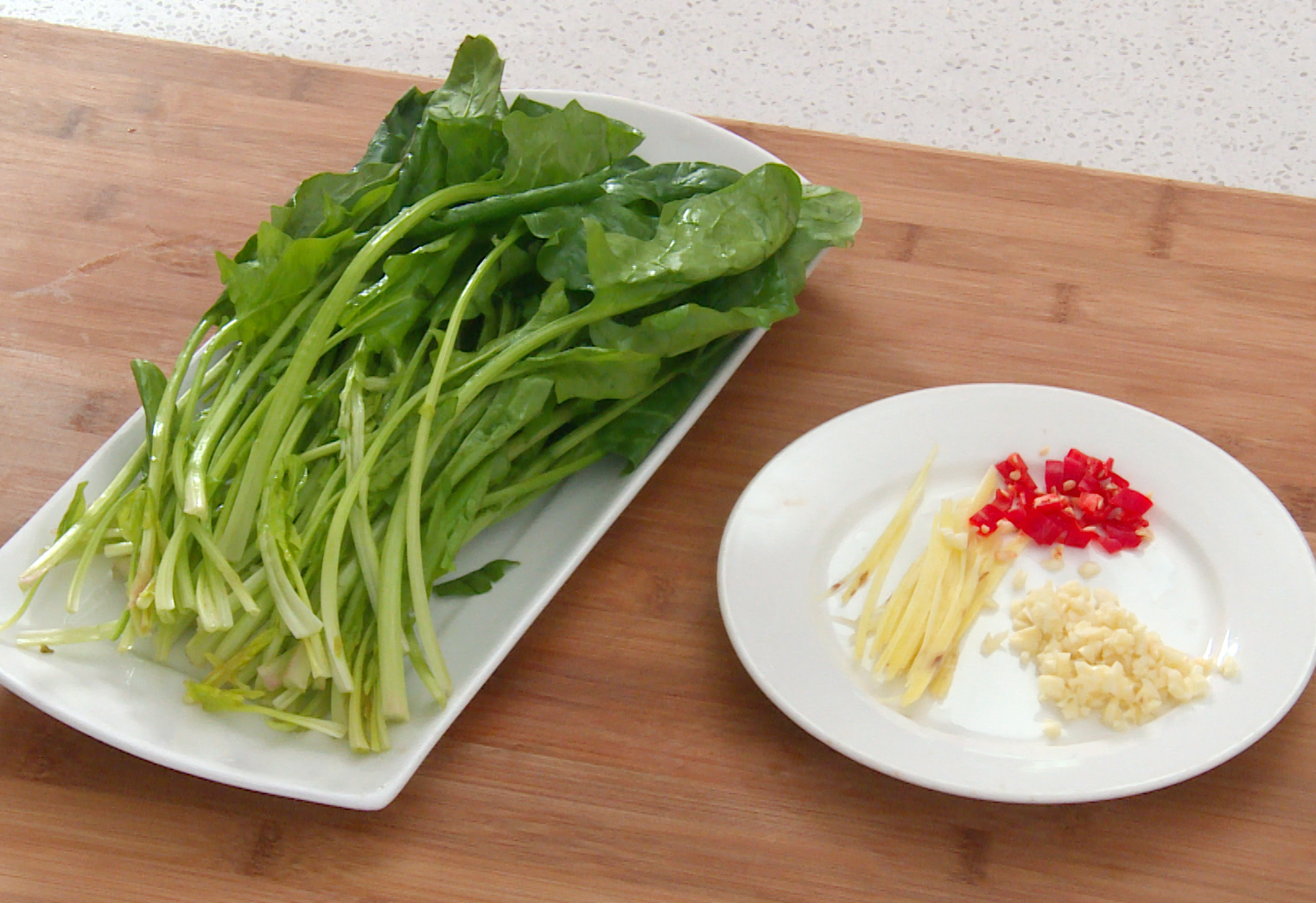 Prepare ingredients: Trim roots off spinach, slice ginger, mince garlic, chop chili. Keep aside.