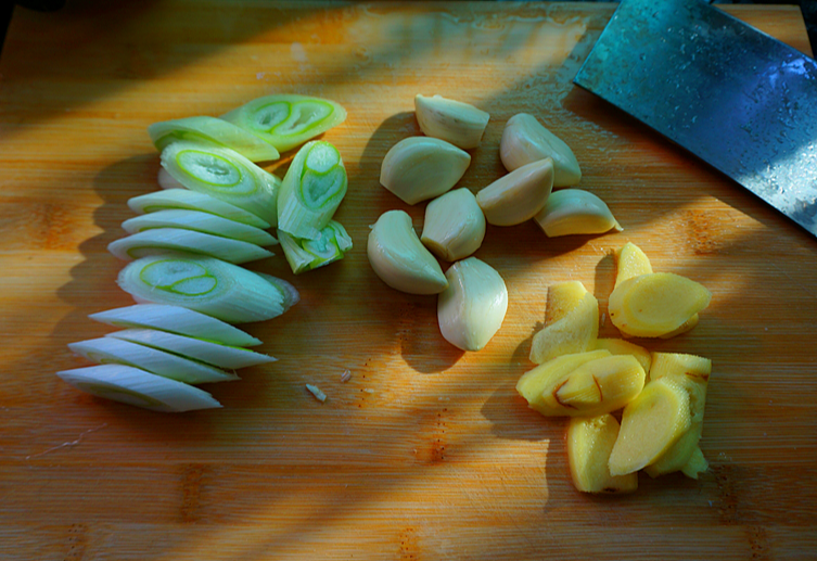 Prepare garlic, onion, and ginger for cooking.