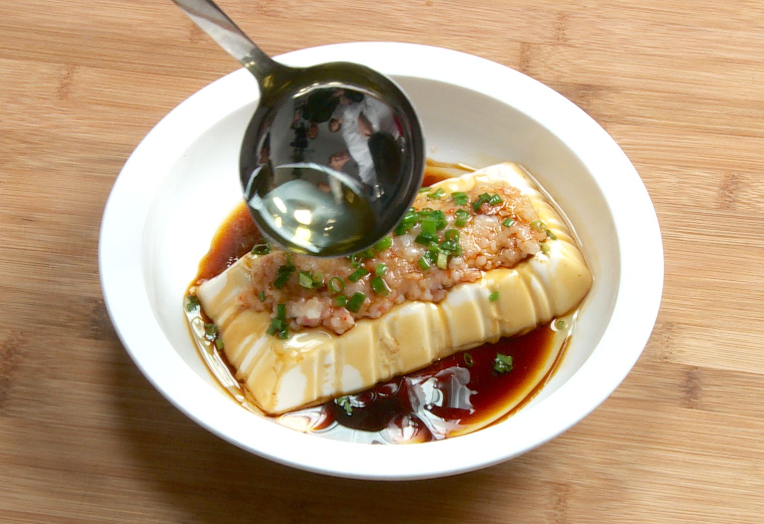 Finish dish: Sprinkle green onions, drizzle soy sauce, pour hot oil over tofu and shrimp paste for flavor.