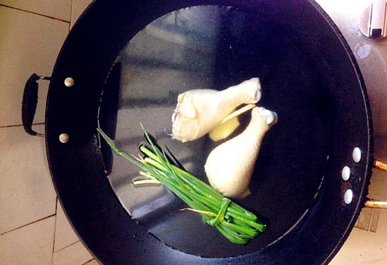 Clean pot, add water, green onion, ginger. Boil, remove chicken legs. Rinse legs with cold water. Avoid tear skin.