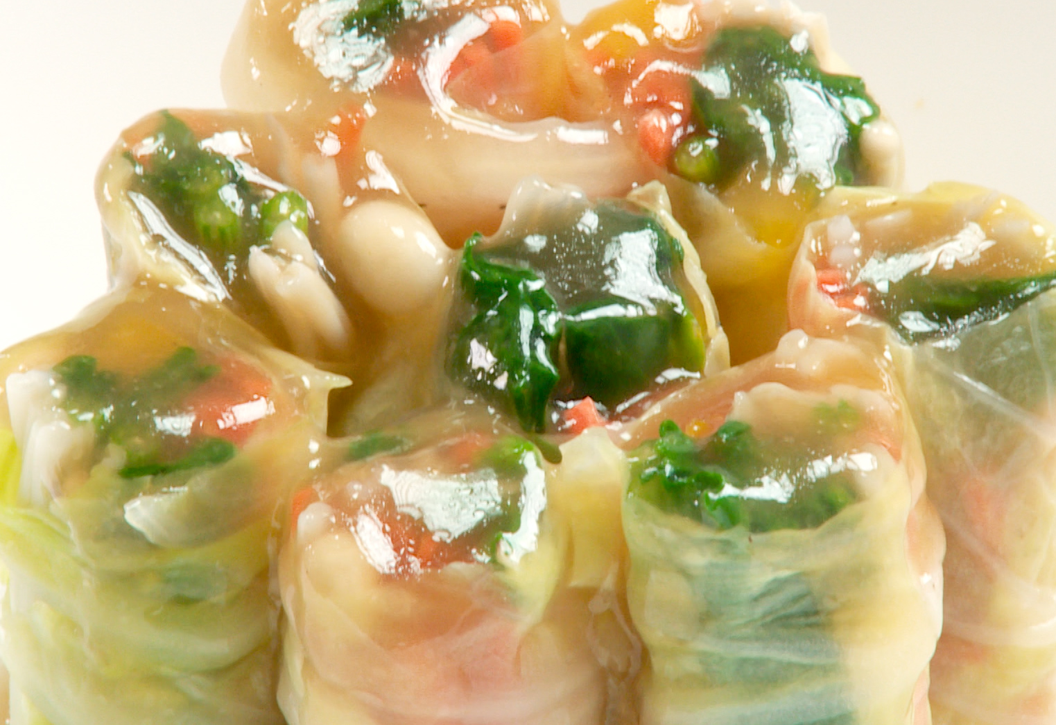 Serve Jade Vegetable Rolls upright on a plate with sauce poured over.