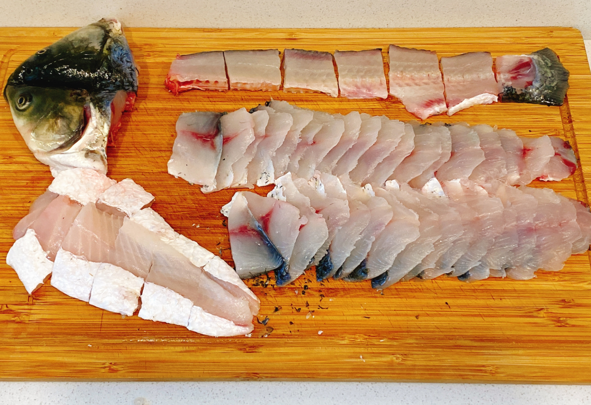 Instructions for breaking down a fish by filleting along bones, separating meat & bones, and slicing meat.