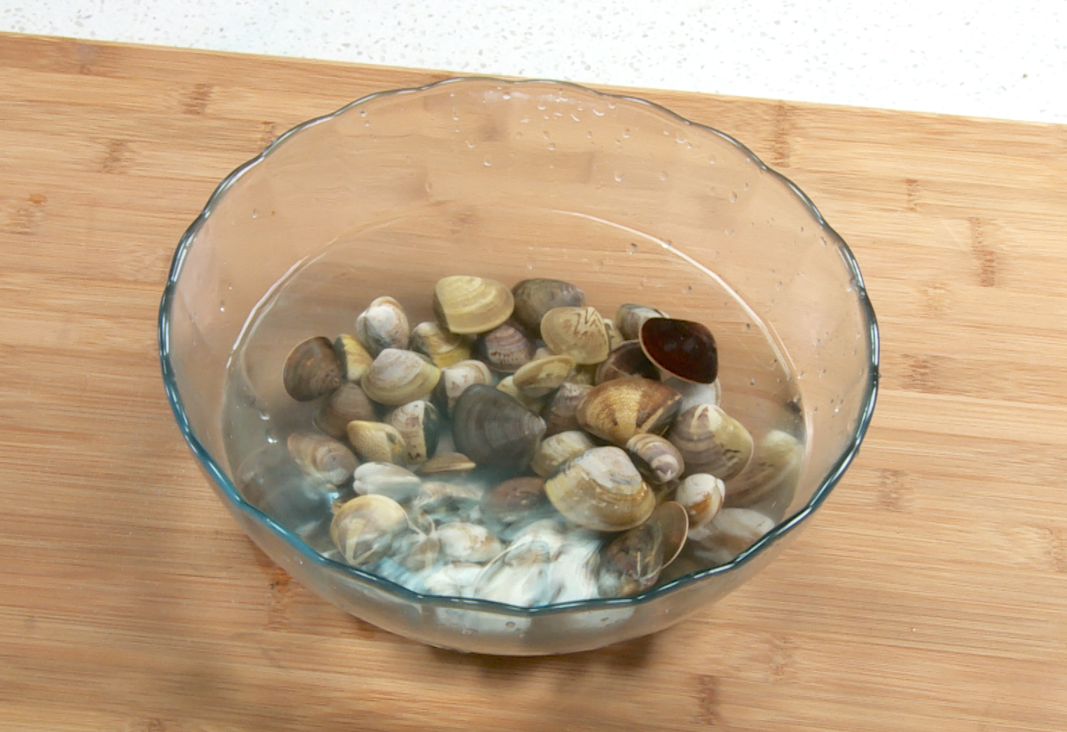 Instructions to prepare fresh clams by soaking in salt water to remove sand.