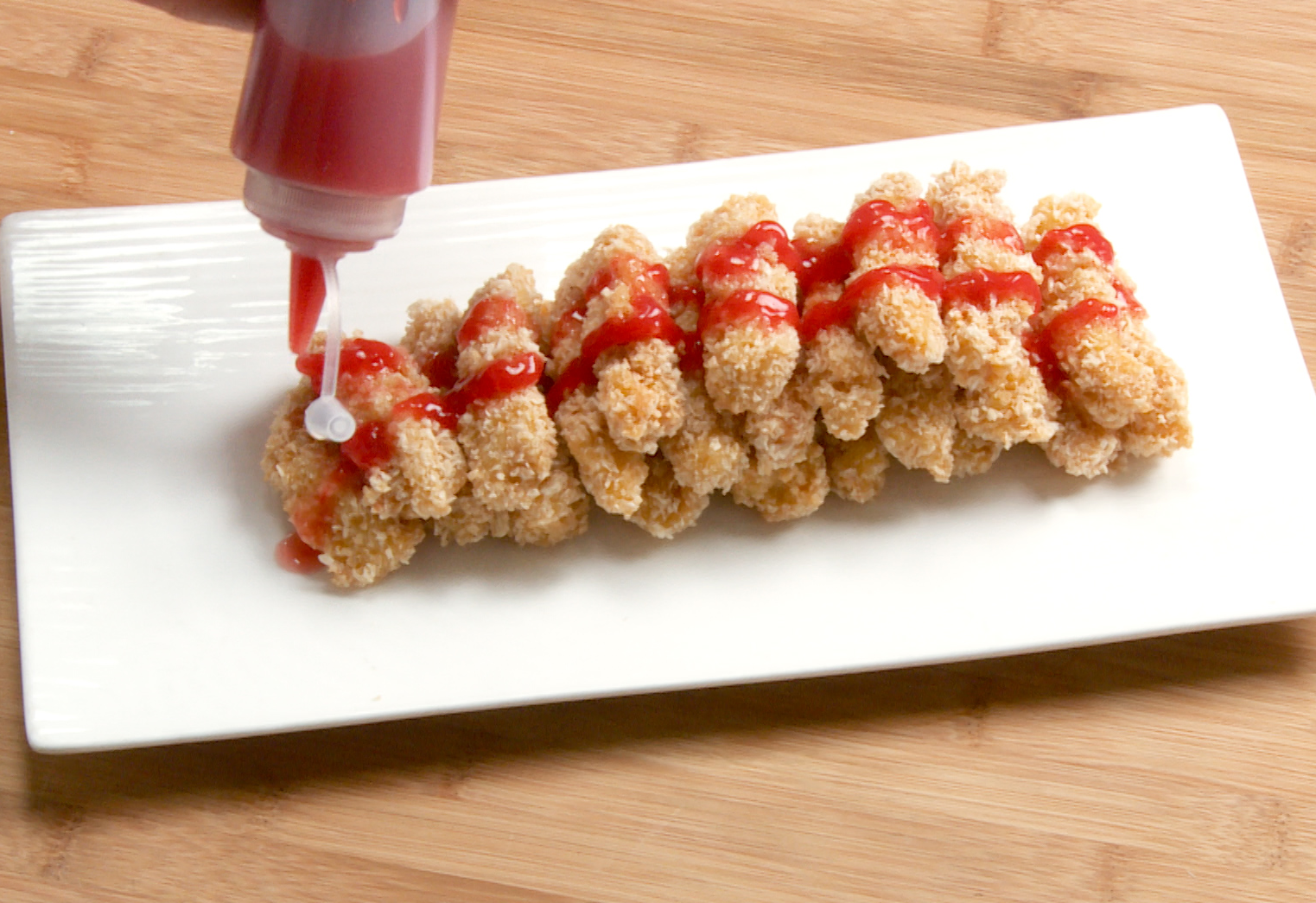 Serve crispy chicken tenders with ketchup on the side for dipping.