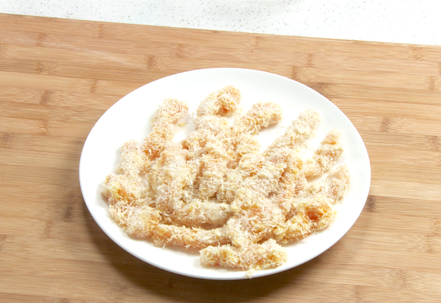 Coat chicken strips in egg and breadcrumbs for breading.