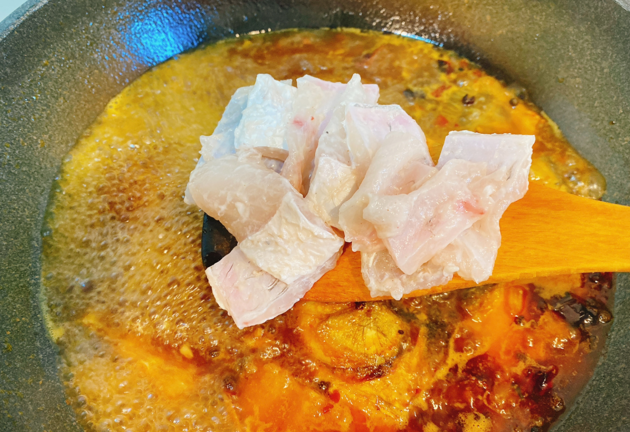 Add fish breastbones to the pot for cooking.