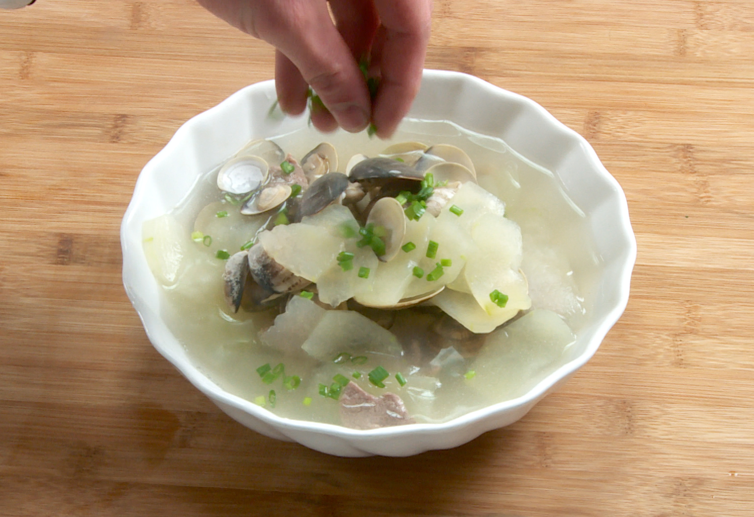 Serve Clam and Winter Melon Soup in a bowl with cilantro and green onions. Enjoy!