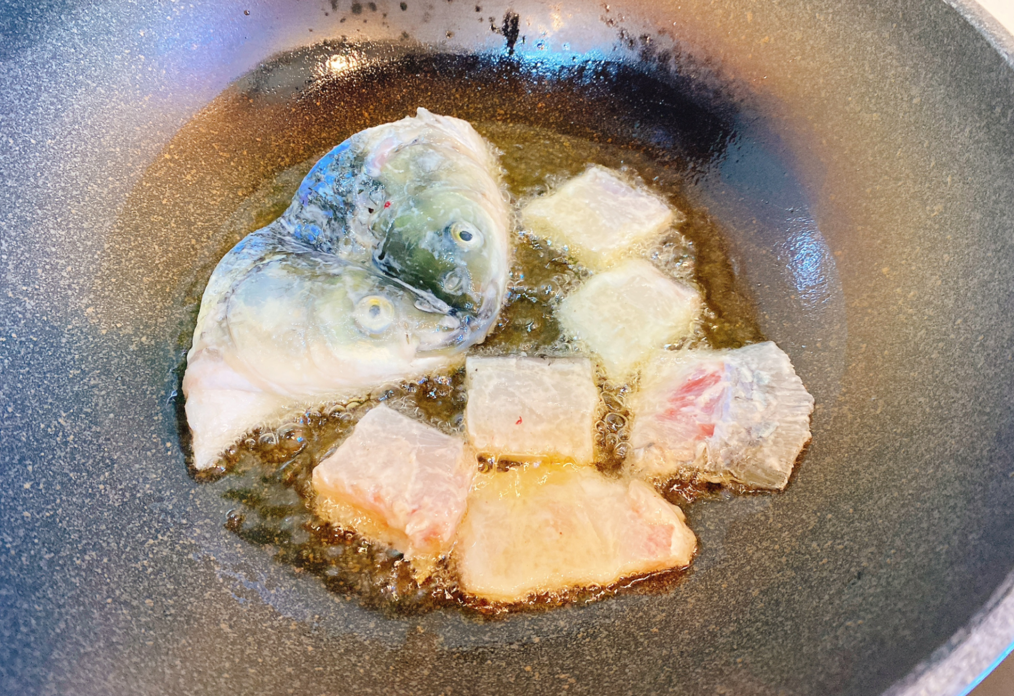 Pan-fry fish head and bones until golden brown.