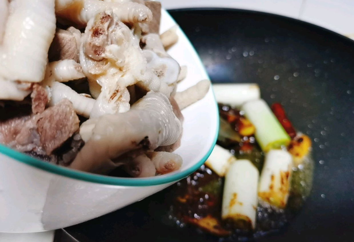 Cook the blanched beef and chicken feet in pot until partially cooked.