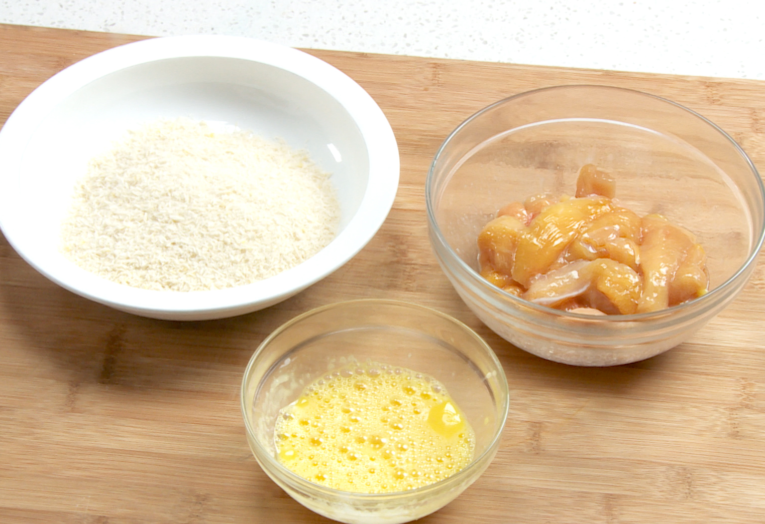 Prepare breading station with eggs, breadcrumbs, and marinated chicken.