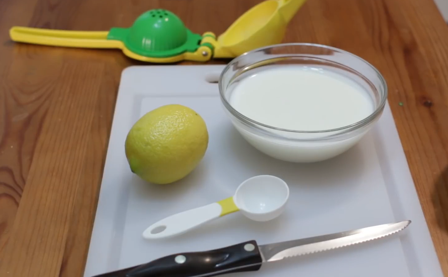 Prepare lemon, milk. Use fruit knife, lemon juicer, tablespoon, spoon.