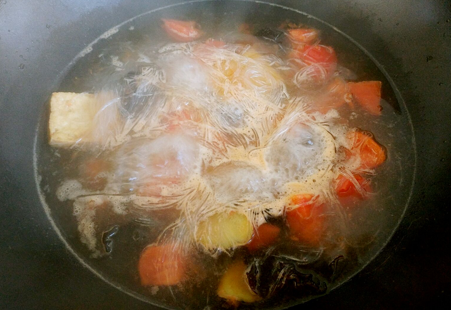 Cook soaked glass noodles in soup base until boiling.