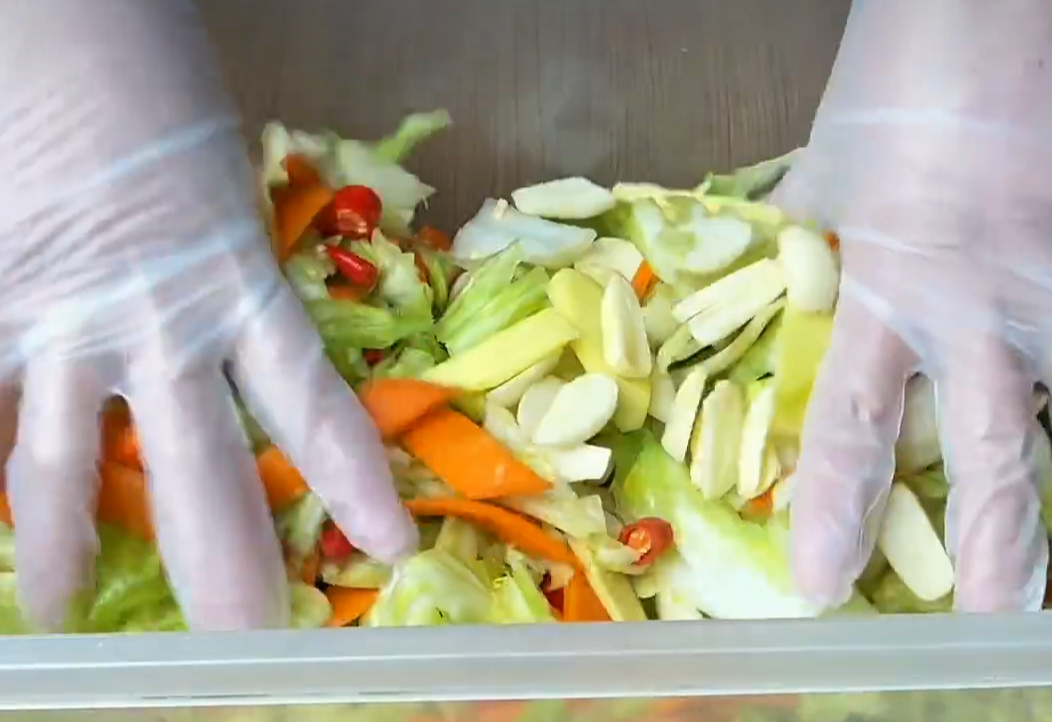 Add chili peppers, ginger, and garlic to cabbage.