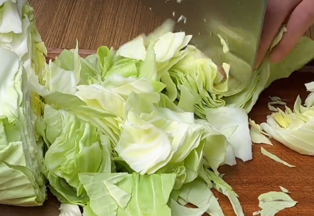 Chop 500g cabbage into small pieces for recipe preparation.