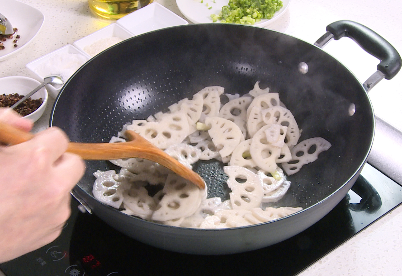 Stir-fry lotus root with green onion for a flavorful dish.